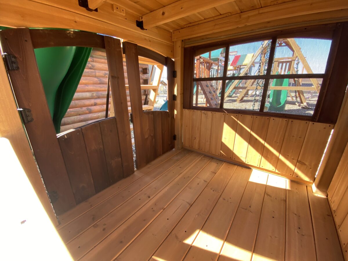 wooden swing set with slide and indoor hang out area